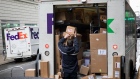 A worker unloads packages from a FedEx delivery truck in New York.