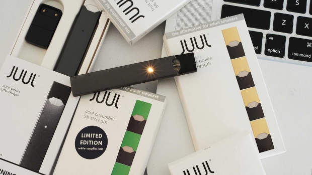 A Juul Labs e-cigarette, USB charger, and flavored pods. Photographer: Gabby Jones