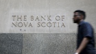A pedestrian passes in front of a building displaying The Bank of Nova Scotia (Scotiabank) signage in the financial district of Toronto, Ontario, Canada, on Thursday, July 25, 2019. 
