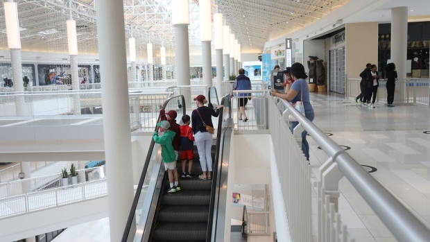Shoppers wearing protective masks ride an escalator at the Mall of America in Bloomington, Minnesota on June 10.