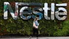 A pedestrian passes a Nestle SA logo at the Nescafe factory, operated by Nestle SA, in Tutbury, U.K., on Thursday, Aug. 23, 2018. European consumer-goods giants ranging from Nestle SA to Anheuser-Busch InBev NV and Diageo Plc are stepping up their response to activist threats by cutting costs, shedding underperforming brands and returning cash to investors. Photographer: Simon Dawson/Bloomberg