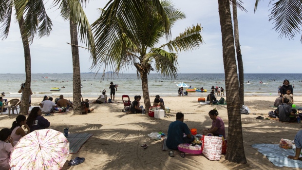 Visitors sit in groups as they relax on the beach and in the sea at Bangsaen Beach in Chonburi, Thailand, on Sunday, June 14, 2020. Thailand said a number of countries, including China and Japan, are interested in discussions about travel bubbles, as the nation considers protocols for the eventual return of foreign tourists. Local tourism has already restarted. Photographer: Andre Malerba/Bloomberg