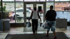 Customers carrying shopping bags exit from a mall in Syracuse, New York on July 10. Photographer: Maranie Staab/Bloomberg