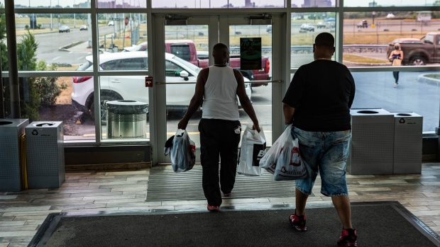Customers carrying shopping bags exit from a mall in Syracuse, New York on July 10. Photographer: Maranie Staab/Bloomberg