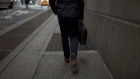 A pedestrian walks along a street near the New York Stock Exchange