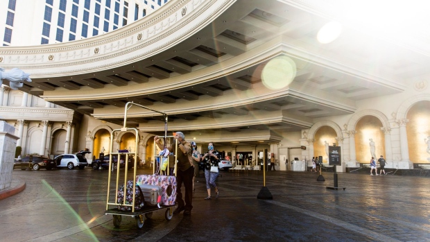 A bellhop helps a guest with their luggage outside the Caesars Entertainment Inc. Caesars Palace hotel and casino in Las Vegas, Nevada, U.S., on Tuesday, July 28, 2020. Caesars Entertainment is scheduled to release earnings figures on August 6. Photographer: Roger Kisby/Bloomberg