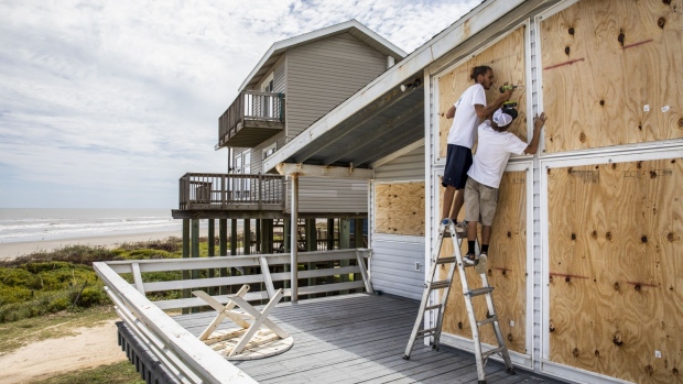 Workers board up a beach-front house ahead of Hurricane Laura in Galveston, Texas on Aug. 25. Photographer: Scott Dalton/Bloomberg