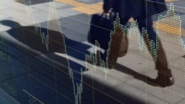 A businessman is reflected on an electronic stock board outside a securities firm in Tokyo, Japan,.