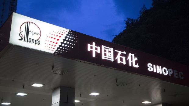 Signage atop a China Petroleum & Chemical Corp. (Sinopec) gas station stands lluminated at dusk in Hong Kong, China, on Tuesday, Aug. 22, 2017. Sinopec is scheduled to report second-quarter results on Aug. 25.