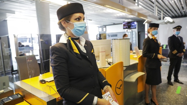 A Deutsche Lufthansa AG crew member holds sachets of disposable handwipes as the airline and airport operator Fraport AG showcase new coronavirus safety measures at Frankfurt Airport in Frankfurt, Germany, on Wednesday, June 17, 2020. Deutsche Lufthansa said a low turnout at its extraordinary general meeting next week is placing its 9 billion-euro ($10 billion) German bailout at risk of falling apart.