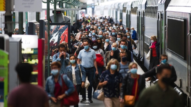 Morning rush hour commuters wear protective face masks after alighting from a train at Gare Du Nord railway station in Paris, France, on Wednesday, Aug. 26, 2020. France’s government gave further hints on Wednesday about the contents of its 100 billion-euro ($118 billion) plan to boost the economy as it seeks to reassure the country it has the situation under control.