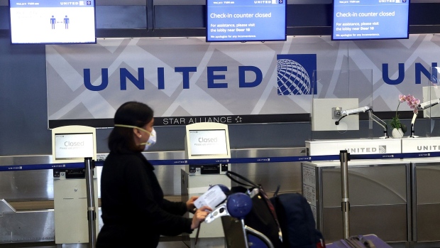 SAN FRANCISCO, CALIFORNIA - JULY 08: A United Airlines passenger pushes a luggage cart past closed check-in kiosks at San Francisco International Airport on July 08, 2020 in San Francisco, California. As the coronavirus COVID-19 pandemic continues, United Airlines has sent layoff warnings to 36,000 of its front line employees to give them a 60 day notice that furloughs or pay cuts could occur after October 1. (Photo by Justin Sullivan/Getty Images)