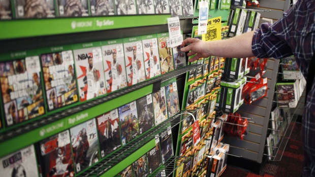 An employee arranges Microsoft Corp. Xbox One video games inside a GameStop retail store in Louisville, Kentucky.