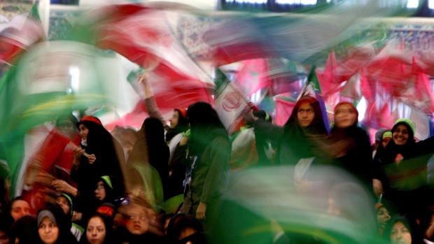 Members of Iran's Basij Islamist militia wave Iranian flags during a ceremony marking the 30th anniversary of its establishment at the Imam Khomeini Grand Mosque in Tehran.