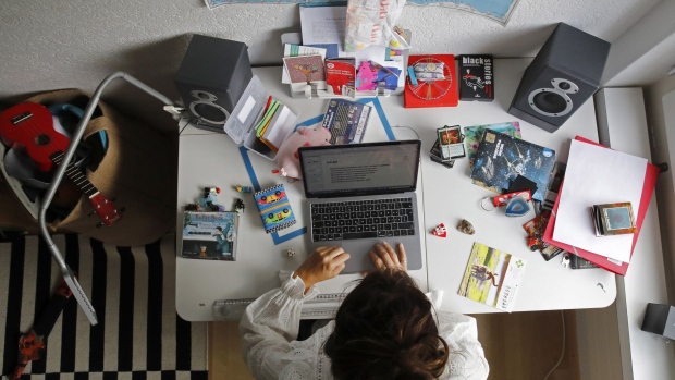A woman works at an Apple Inc. laptop computer on a desk in a children's bedroom in this arranged photograph taken in Bern, Switzerland, on Saturday, Aug. 22, 2020. The biggest Wall Street firms are navigating how and when to bring employees safely back to office buildings in global financial hubs, after lockdowns to address the Covid-19 pandemic forced them to do their jobs remotely for months. Photographer: Stefan Wermuth/Bloomberg