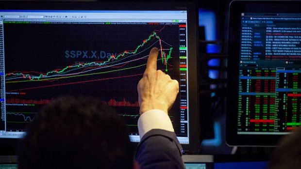 A trader points to monitor displaying an S&P 500 Index (SPX) chart on the floor of the New York Stock Exchange (NYSE) in New York, U.S., on Friday, Feb. 16, 2018. 