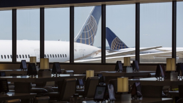 United Airlines Holdings airplanes stand past an empty waiting area for travelers at Newark International Airport on June 9.