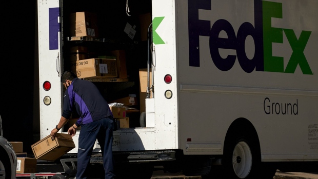 A FedEx Corp. worker wearing a protective mask unloads a truck in downtown Dallas, Texas, U.S., on Wednesday, May 27, 2020. Texas Governor Greg Abbott allowed bars—along with rodeos, bowling alleys and bingo halls—to open their doors at reduced capacity in the second phase of the state’s plan to restart the economy after shutting down in early April to slow the coronavirus.