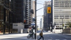 A pedestrian crosses Bay Street in the financial district of Toronto, Ontario, Canada, on Friday, May 22, 2020.