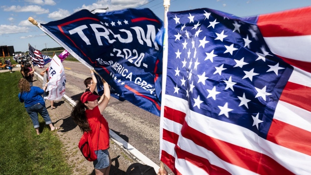 MANKATO, MN - AUGUST 17: Supporters wave flags outside of Mankato Regional Airport as President Donald Trump makes a campaign stop on August 17, 2020 in Mankato, Minnesota. Trump spoke at the airport before continuing on to a campaign stop in Oshkosh, Wisconsin. (Photo by Stephen Maturen/Getty Images)