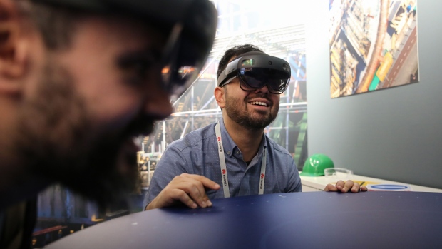 Attendees wear Microsoft Corp. HoloLens 2 headsets as they use the Bentley Systems Inc. Synchro XR augmented reality (AR) app, at the Microsoft Corp. stand on the opening day of the MWC Barcelona in Barcelona, Spain, on Monday, Feb. 25, 2019. At the wireless industry’s biggest conference, over 100,000 people are set to see the latest innovations in smartphones, artificial intelligence devices and autonomous drones exhibited by more than 2,400 companies.