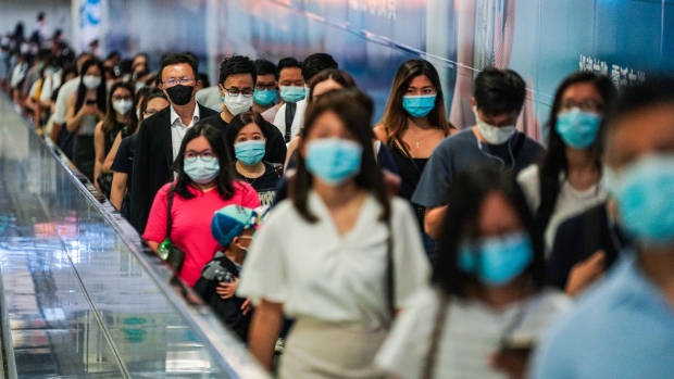 Commuters wearing protective masks walk through Hong Kong Station, operated by MTR Corp., in Hong Kong, China, on Wednesday, July 15, 2020. Hong Kong implemented its strictest suite of social distancing measures yet as the Asian financial hub looks set to be the first in the region where a new outbreak surpasses previous waves in severity. Photographer: Lam Yik/Bloomberg