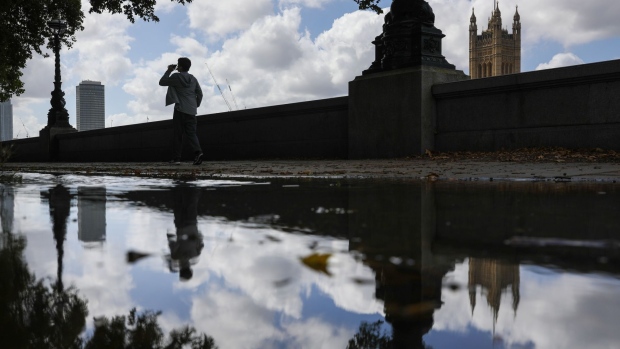 A pedestrian walks along the Thames Path near the River Thames past the Houses of Parliament in London, U.K., on Thursday, Aug. 20, 2020. Londoners' demand for public transportation was almost unchanged in the week to Aug. 16: it remained 52% below pre-coronavirus levels, according to Moovit App Global Ltd. data. Photographer: Simon Dawson/Bloomberg