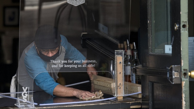 A worker cleans a plexiglass shield at a pizza restaurant in San Francisco. Photographer: David Paul Morris/Bloomberg