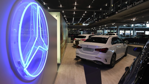 An illuminated Mercedes-Benz trident logo sits on display near luxury automobiles, manufactured by Daimler AG, in the automaker's showroom in Munich, Germany, on Tuesday, July 7, 2020.
