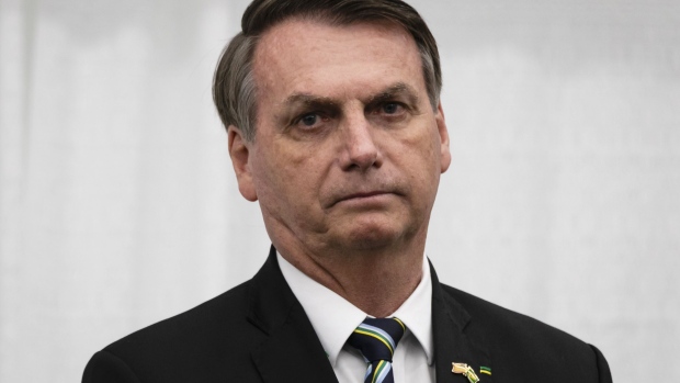Jair Bolsonaro, Brazil's president, wears a protective mask while attending a ceremony at Planalto Palace in Brasilia, Brazil, on Tuesday, Aug. 25, 2020. Disagreement between Bolsonaro and Economy Minister Paulo Guedes over the size and the shape of a new social program led the government to postpone the announcement of its post-pandemic economic plan, leaving the government to announce only a new housing initiative instead.