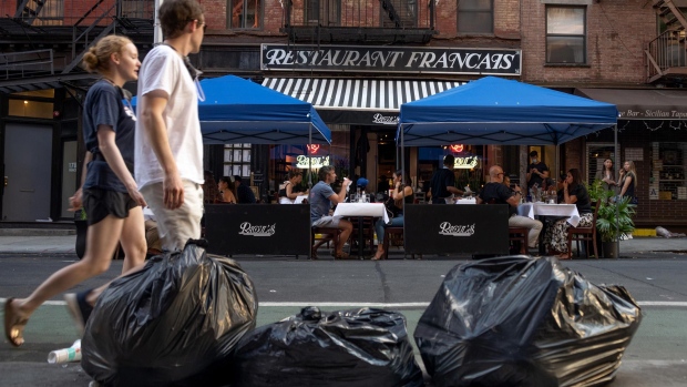 NEW YORK, NEW YORK - JUNE 24: Trash bags are see across the street from customers eating outside at Raoul's as the city moves into Phase 2 of re-opening following restrictions imposed to curb the coronavirus pandemic on June 24, 2020 in New York City. Phase 2 permits the reopening of offices, in-store retail, outdoor dining, barbers and beauty parlors and numerous other businesses. New York state plans on re-opening in four phases. (Photo by Alexi Rosenfeld/Getty Images)