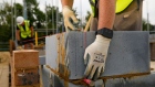 A bricklayer uses wearable technology, which vibrates when wearer breaches social distancing guidelines, on a Bewley Homes Plc residential construction site in Ash, near Farnborough, U.K. on Friday, June 12, 2020. New practices on construction sites will incorporate social distancing and workers in two-person tasks will use personal protective equipment. Photographer: Luke MacGregor/Bloomberg