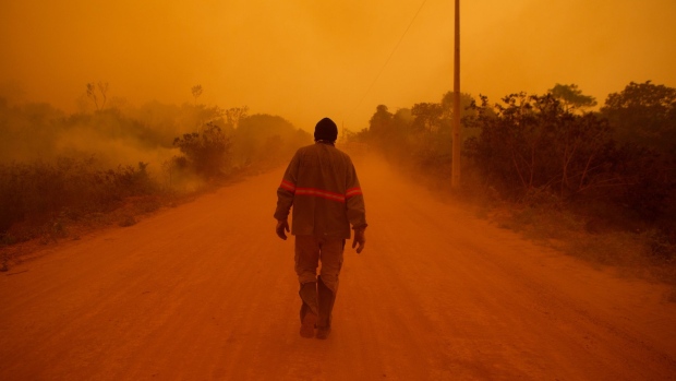 A volunteer firefighter walks along Transpantaneira road at the Pantanal wetlands region in Porto Jofre city, Mato Grosso state, Brazil, on Friday, Sept. 11, 2020. In July, the number of fires burning in the Pantanal, which spans about 210,000 square kilometers (81,100 square miles), reached the highest for the month since the data started being collected in 1998.