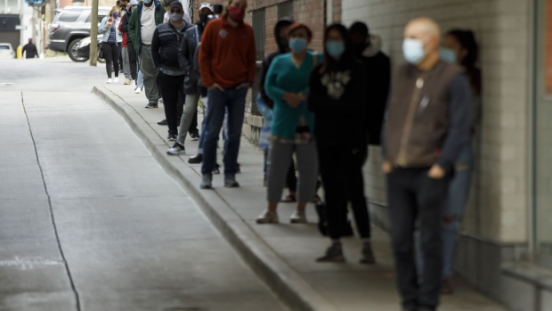 People wait in line outside a C-19 testing center at St. Michael's Hospital in Toronto, Ontario, Canada, on Friday, Sept. 18, 2020. 