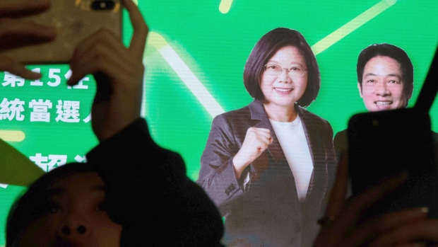 Attendees take photographs in front of a screen displaying an image of Taiwanese President Tsai Ing-wen, left, during a Democratic Progressive Party (DPP) rally in Taipei, Taiwan, on Saturday, Jan. 11, 2020. Tsai won a landslide victory over China-friendly opposition challenger Han Kuo-yu to clinch a second term in Taiwans presidential election, dealing a blow to Beijing, which has long sought to bring the democratically run island under its control. Photographer: Betsy Joles/Bloomberg