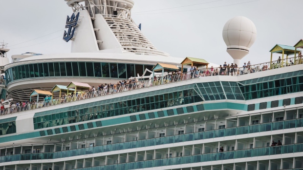 Passengers stand on board the Royal Caribbean Cruises Ltd. Navigator Of The Seas cruise ship at the Port of Miami in Miami, Florida, U.S., on Monday, March 9, 2020. At the world's busiest cruise port, thousands of vacationers paid little heed to a government warning that Americans should avoid setting sail on the massive ships.