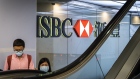 Customers wearing protective face masks use an escalator at the HSBC Holdings Plc headquarters building in Hong Kong, China, on Monday, Sept. 21, 2020. HSBC slumped below its financial crisis low set more than a decade ago as pressures mount on several fronts including a potential threat to its expansion plans in China. Photographer: Chan Long Hei/Bloomberg