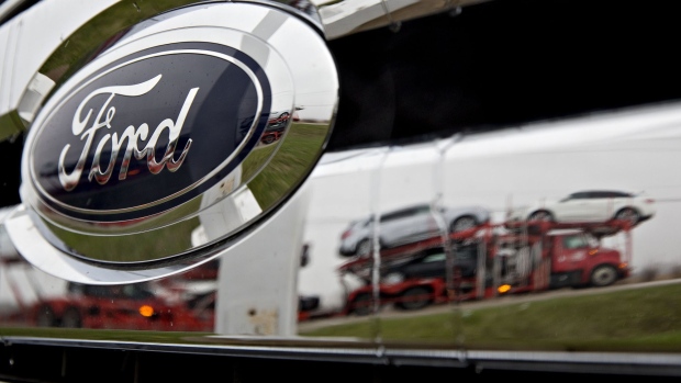 A passing car carrier is reflected in the grille of a 2017 Ford Motor Co. F-150 pickup truck on display at the Sutton Ford Lincoln car dealership in Matteson, Illinois, U.S., on Monday, April 3, 2017. Ward's Automotive Group released U.S. monthly total and domestic auto sales figures on April 3