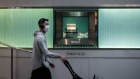 A pedestrian wears a face mask while pushing a stroller past the Tiffany & Co. luxury goods store at Times Square in the Causeway Bay district of Hong Kong, China, on Thursday, Feb. 6, 2020. 