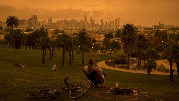 A person sits in Delores Park as smoke and fog hang over the skyline in San Francisco, California, U.S., on Wednesday, Sept. 9, 2020. Powerful, dry winds are sweeping across Northern California for a third day, driving up the risk of wildfires in a region thats been battered by heat waves, freak lightning storms and dangerously poor air quality from blazes. Photographer: David Paul Morris/Bloomberg