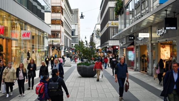 Pedestrians pass shops on Drottninggatan in Stockholm on Sept. 21. Photographer: Mikael Sjoberg/Bloomberg