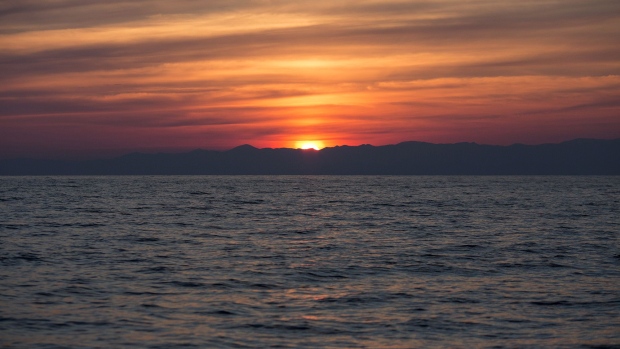 The sun rises over the Turkish coastline in the Aegean sea between Turkey and Greece.