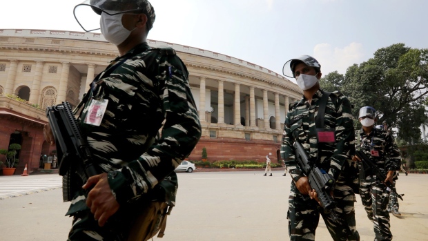 Armed members of the paramilitary forces wearing protective masks and face shields patrol the premises of Parliament House in New Delhi, India, on Sunday, Sept. 13, 2020. Indian lawmakers returned to the nation's parliament for the first time since the start of the pandemic with Prime Minister Narendra Modi's government bracing for a tumultuous session as the country sets new global records in coronavirus infections, and with a tense border standoff with China dominating the headlines. Photographer: T. Narayan/Bloomberg