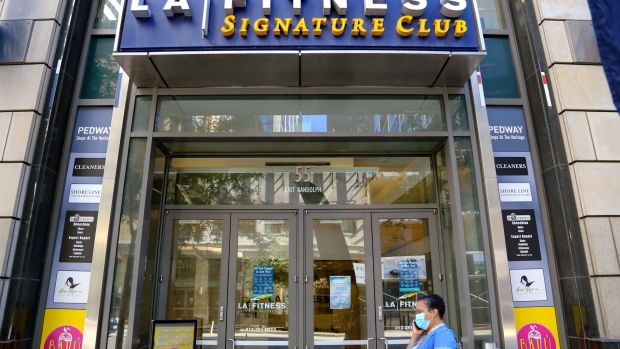 A pedestrian wearing a protective mask passes in front of an LA Fitness Ltd. Signature Club gym in Chicago, Illinois, U.S., on Friday, July 24, 2020. Chicago is reinstating restrictions “in certain high-risk environments” for the first time since reopening its economy last month to prevent an uptick in Covid-19 cases from turning into a resurgence. Photographer: Olivia Obineme/Bloomberg
