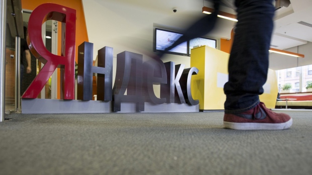 A visitor walks past a logo displayed in the reception area at the headquarters of Yandex NV in Moscow, Russia, on Tuesday, Sept. 19, 2017. Yandex NV, the maker of Russia’s most-popular internet search engine, has created a set of services for some connected Toyota Motor Corp. and Tata Motors Ltd vehicles sold in the country as it seeks to expand beyond desktop and smartphones.