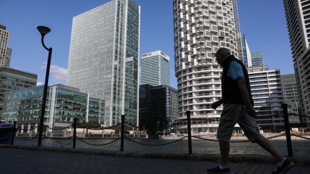 A pedestrian passes the HSBC Holdings Plc headquarters office building, center, in the Canary Wharf business, financial and shopping district of London, U.K., on Friday, Sept. 18, 2020. After a pause during lockdown, lenders from Citigroup Inc. to HSBC Holdings Plc have restarted cuts, taking gross losses announced this year to a combined 63,785 jobs, according to a Bloomberg analysis of filings. Photographer: Simon Dawson/Bloomberg