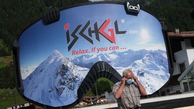 ISCHGL, AUSTRIA - SEPTEMBER 10: A man removes a protective face mask after photographing himself in front of an advertisement in the shape of ski goggles for the Ischgl ski resort on September 10, 2020 in Ischgl, Austria. Ischgl became a superspreader locality for coronavirus infections among winter vacationers last March and authorities have pointed to crowded apres-ski venues as a strong contributing factor. At least 28 people died and 6,000 people world-wide have registered with an Austrian lawyer claiming they think they were infected in Ischgl. Meanwhile Ischgl's hotels, restaurants, ski lift operator and other businesses that are dependent on tourism are taking measures they hope will bring tourists back for the coming winter ski season and minimize the risk of Covid infections. (Photo by Sean Gallup/Getty Images)