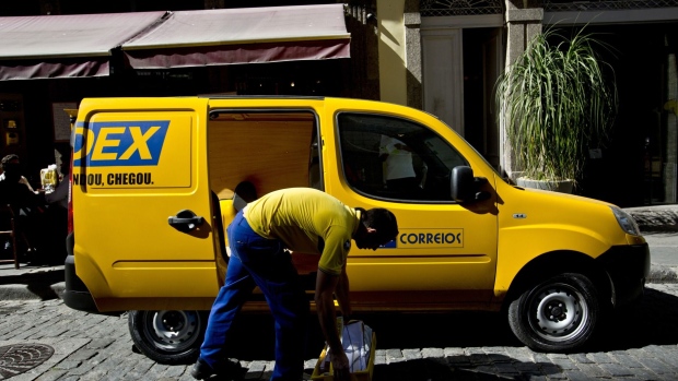 A postal worker takes some mail from a vehicle in Rio de Janeiro, Brazil, on Thursday, Aug. 7, 2014. Brazilian postal workers became unlikely victims of Argentina's default last week after a $168 million fund used by their pension plan recorded a loss on most of its assets.