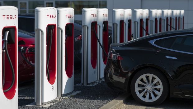 Tesla Inc. electric automobiles sit charging at a Tesla Supercharger station in Zaltbommel, Netherlands.