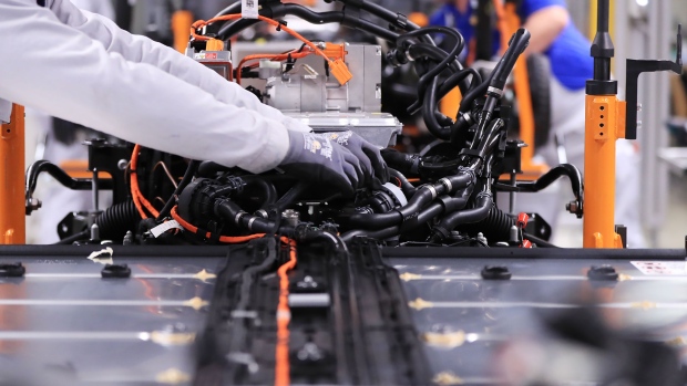 An employee connects cables between an electric motor and lithium-ion automotive battery on the Volkswagen AG (VW) ID.3 electric automobile assembly line in Zwickau, Germany, on Tuesday, Feb. 25, 2020. The world’s largest automaker plans to eliminate carbon dioxide emissions by 2050 and will invest 33 billion euros through 2024 to build the industry’s biggest fleet of electric cars.